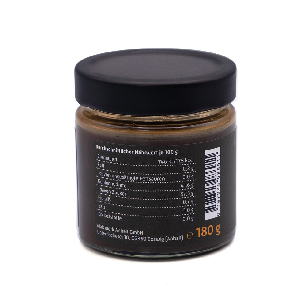 Ein elegantes schwarzes Glas mit Nährwertangaben auf weißem Hintergrund und einem Gewicht von 180 g passt perfekt zum reichen Geschmack von Gerstenmalz. Produkt: BIO Malzaufstrich dunkel von malzit.