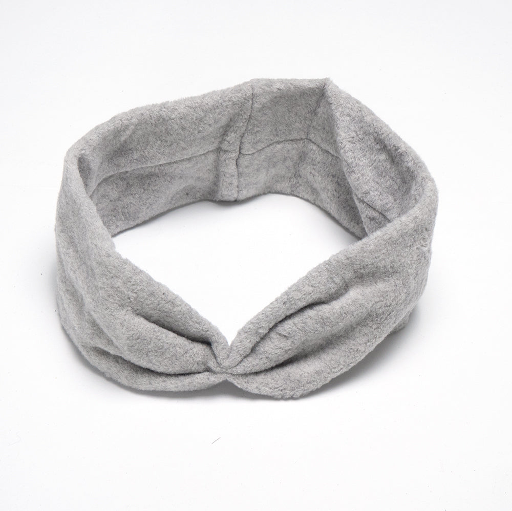 Das Bio-Stirnband von ShipSheip ist ein graues, fair produziertes Stirnband aus weichem Stoff mit einer Drehung auf der Vorderseite auf weißem Hintergrund.