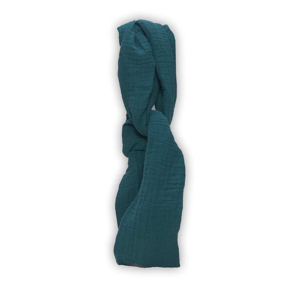 Ein zerknittertes, blaugrünes Haarband von Hutch&Putch aus Bio-Baumwolle liegt elegant vor einem weißen Hintergrund und bietet einen Hauch von nachhaltigem Stil.