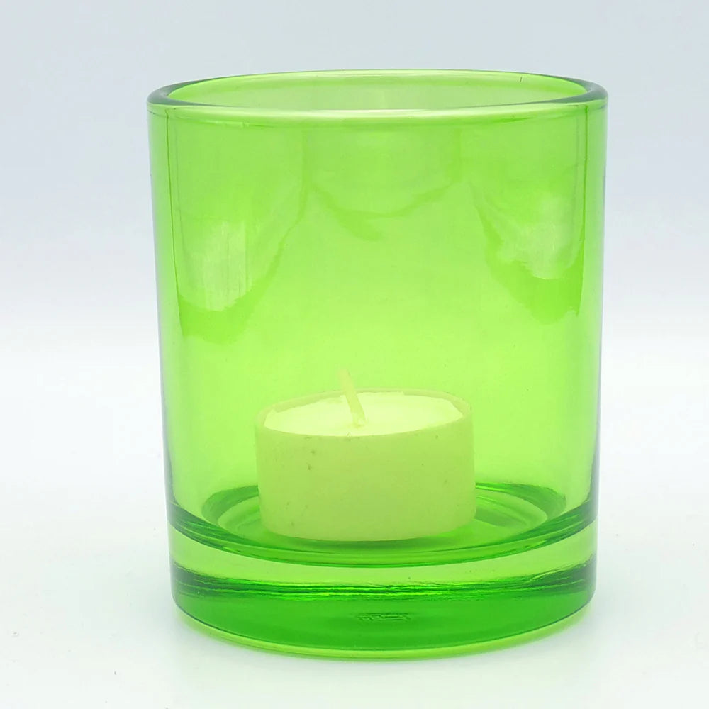 Das TrendRaider Windlicht, ein Kerzenhalter aus grünem Glas, beherbergt ein weißes Teelicht vor einem makellos weißen Hintergrund.